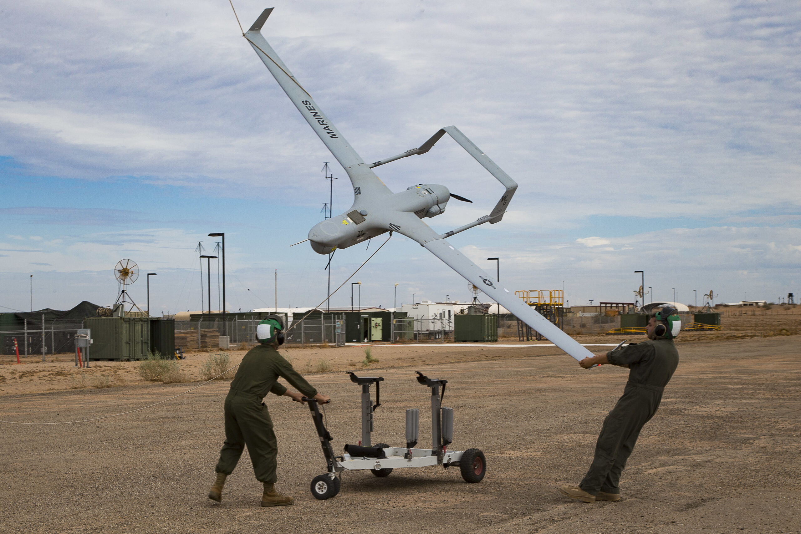 U.S. Marine Corps Lance Cpl. Isaiah Trujillo, an unmanned aircraft system (UAS) maintenance technician with Marine Unmanned Aerial Vehicle Squadron (VMU) 3, Marine Aircraft Group (MAG) 24, 1st Marine Aircraft Wing (MAW), and Lance Cpl. Mario Mendoza, a UAS maintenance technician with VMU-1, MAG-13, 3rd MAW, recover a U.S. Marine Corps RQ-21A Blackjack aircraft during Weapons and Tactics Instructor (WTI) course 1-20 at Canon Air Defense Complex in Yuma, Arizona, Sept. 26, 2019. WTI is a seven week training event hosted by Marine Aviation Weapons and Tactics Squadron One (MAWTS-1), which emphasizes operational integration of the six functions of Marine Corps Aviation in support of a Marine Air Ground Task Force. WTI also provides standardized advanced tactical training and certification of unit instructor qualifications to support Marine Aviation training and readiness, and assists in developing and employing aviation weapons and tactics. (U.S. Marine Corps photo by Cpl. Adaezia Chavez)