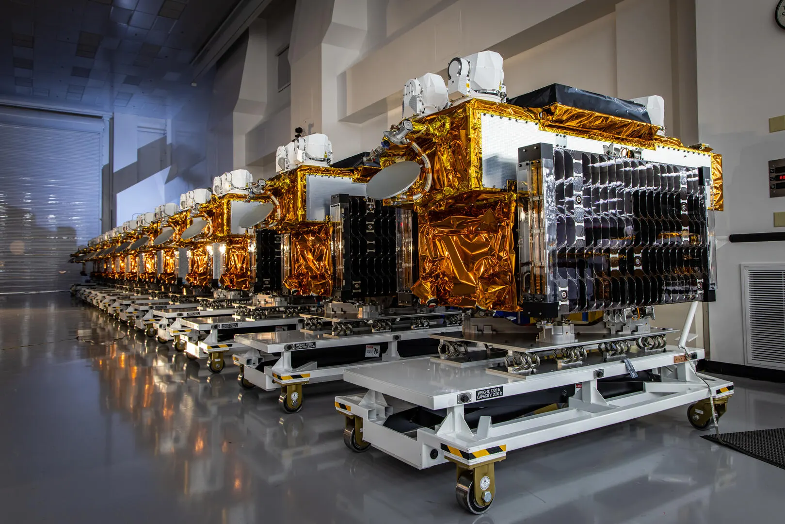 Row of T1TL satellites in a warehouse.