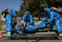 Washington National Guard explosive ordnance technicians with 319th Explosive Ordnance Company (EOD), 741st Ordnance Battalion, 96th Troop Command, transport a casualty from the incident site at the RJ Lee Group Columbia Basin analytical laboratory, in Pasco, Wash., Aug. 14, 2023. 319th EOD hosted a collaborative training exercise attended by members of the Tri-County Regional HAZMAT Team, a specialty organization comprised of fire departments within the Southeast quarter of Washington State. The training scenario focused on strengthening communication and building relationships between the National Guard and community responders. (U.S. Army National Guard photo by Staff Sgt. Adeline Witherspoon)