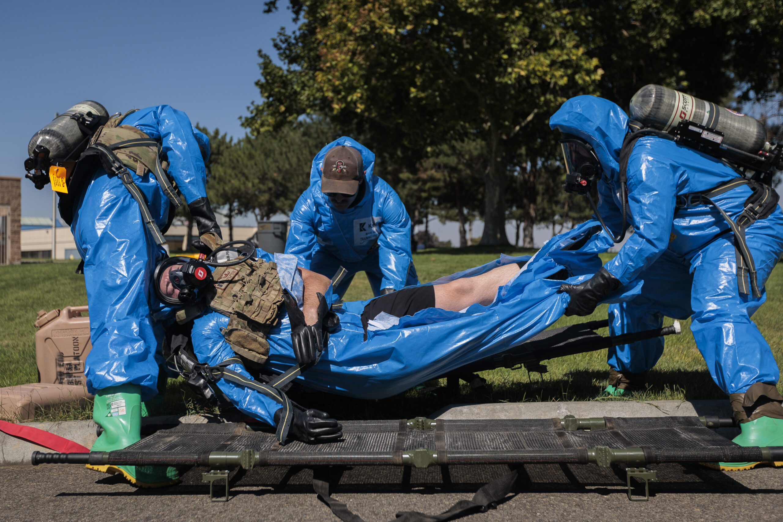 Washington National Guard explosive ordnance technicians with 319th Explosive Ordnance Company (EOD), 741st Ordnance Battalion, 96th Troop Command, transport a casualty from the incident site at the RJ Lee Group Columbia Basin analytical laboratory, in Pasco, Wash., Aug. 14, 2023. 319th EOD hosted a collaborative training exercise attended by members of the Tri-County Regional HAZMAT Team, a specialty organization comprised of fire departments within the Southeast quarter of Washington State. The training scenario focused on strengthening communication and building relationships between the National Guard and community responders. (U.S. Army National Guard photo by Staff Sgt. Adeline Witherspoon)
